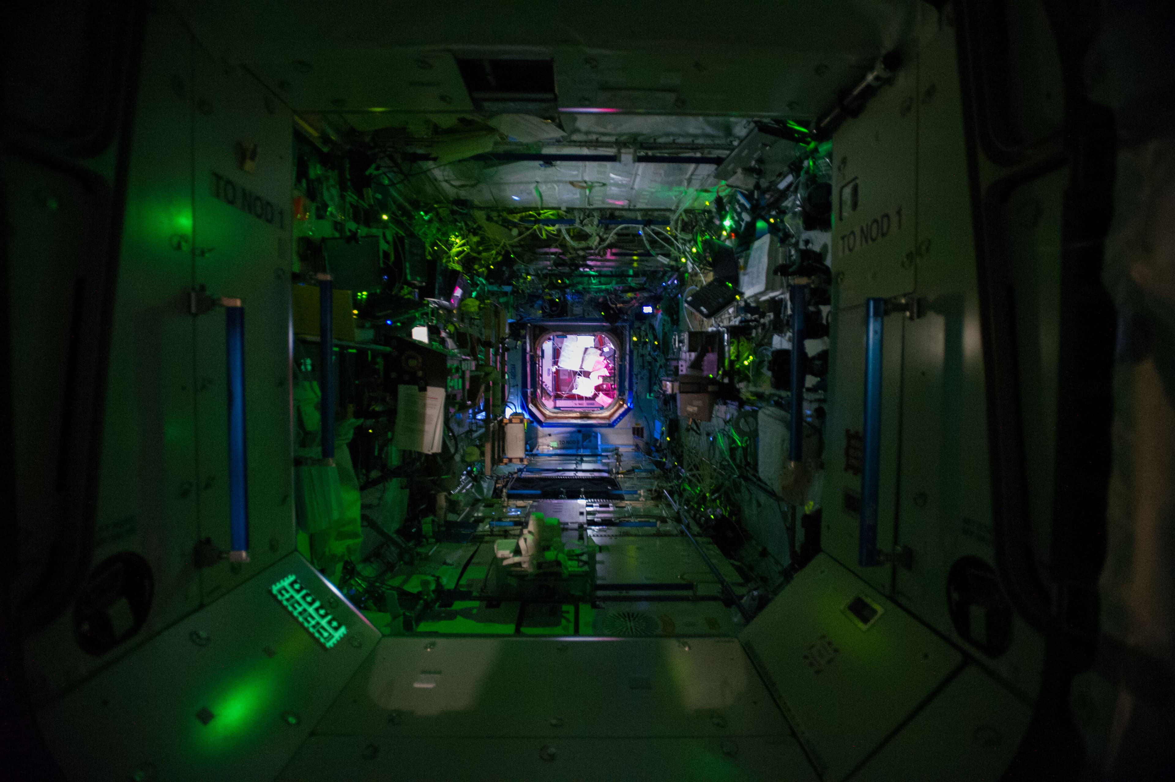 Unoccupied Destiny laboratory interior with equipment racks and a central passage leading towards Harmony