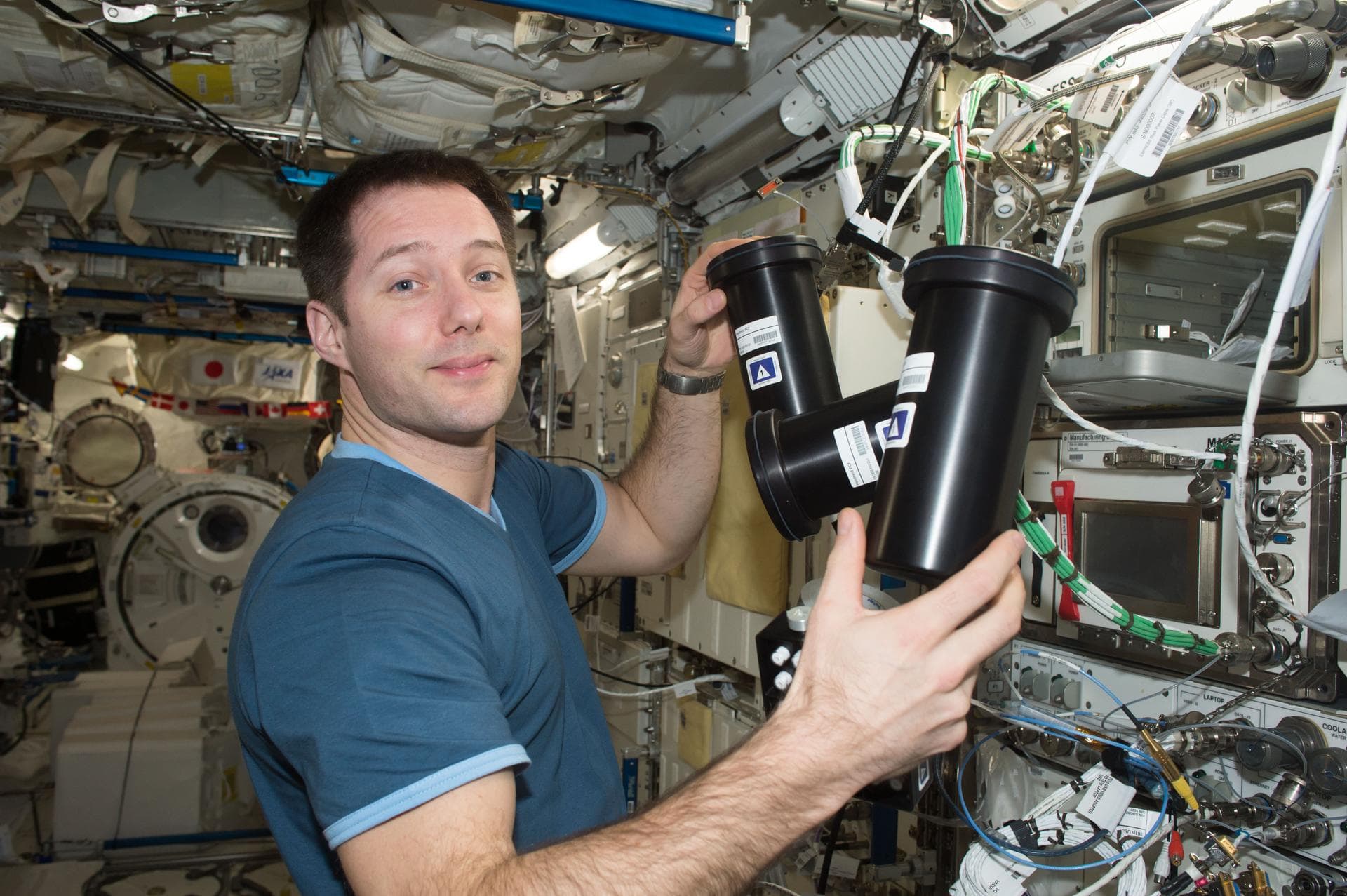ESA astronaut Thomas Pesquet handling protein-crystallisation experiment containers aboard the International Space Station